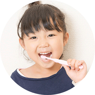 小児歯科に通っている子どもが歯磨きしながら笑っている様子