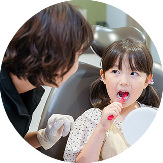 歯科衛生士が子どもに歯磨き指導をしている